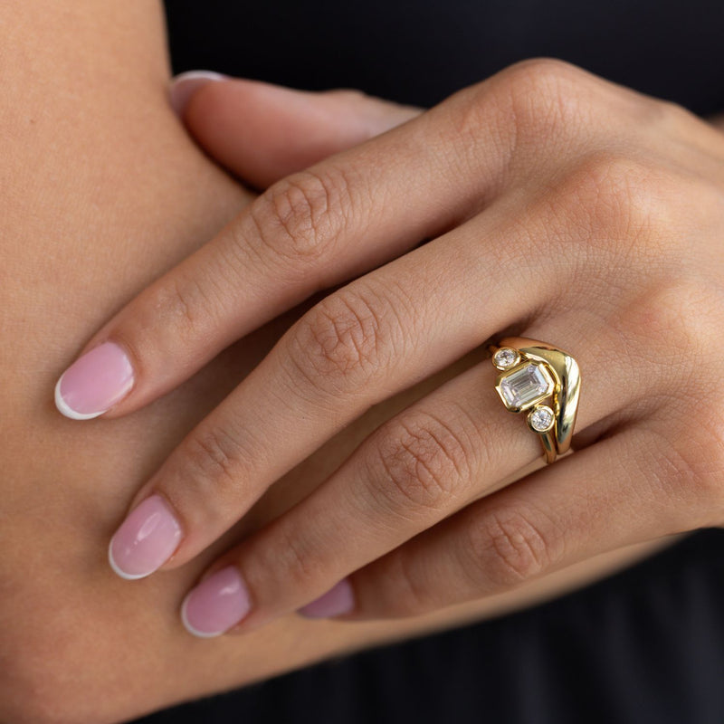 three-stone-emerald-cut-diamond-engagement-ring-round-diamond-accents-bezel-setting-the-marcelline-rustic-and-main